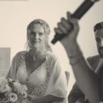 Microphon mit Lisa Schaufler-Hartl im Vordergrund und hinten das Brautpaar. Schwarz-weiß Foto