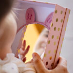 Baby schaut sich in den Spiegel